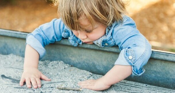 vaikas žaidžia smėlio dėžėje ir užsikrečia kirmėlėmis